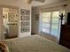 Relaxing bedroom with neutral tones, natural light, and a view into the connected bathroom at 590 Artists Ave, Englewood, FL 34223