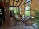 Covered patio features seating, ceiling fan, tongue and groove ceiling and privacy shades at 590 Artists Ave, Englewood, FL 34223