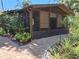Enclosed outdoor patio with a brick floor, privacy screens, and lush landscaping at 590 Artists Ave, Englewood, FL 34223