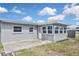 Backyard exterior featuring a concrete patio and sunroom addition at 5905 Olive Ave, Sarasota, FL 34231