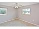 This neutral bedroom features two windows and a ceiling fan for a bright and airy space at 5905 Olive Ave, Sarasota, FL 34231