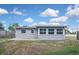 Exterior rear view of house, showing sunroom and partial yard at 5905 Olive Ave, Sarasota, FL 34231