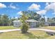 Well-maintained single-story home featuring a large lawn, mature trees, and a concrete driveway at 5905 Olive Ave, Sarasota, FL 34231