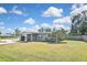 Well-maintained home with a carport, a freshly painted exterior, mature trees, and a spacious lawn at 5905 Olive Ave, Sarasota, FL 34231