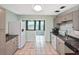 Neutral kitchen features tile floors, gray cabinets, and a view into the naturally lit bonus room at 5905 Olive Ave, Sarasota, FL 34231