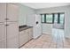 Functional kitchen features tile floors, gray cabinets, and access to a naturally lit bonus room at 5905 Olive Ave, Sarasota, FL 34231