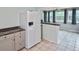 This spacious kitchen is equipped with a refrigerator, light cabinets, and a tiled floor at 5905 Olive Ave, Sarasota, FL 34231