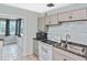 This functional kitchen features tile floors, appliances, and view into the naturally lit bonus room at 5905 Olive Ave, Sarasota, FL 34231