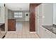 Neutral kitchen features tile floors, gray cabinets, and access to other rooms in the house at 5905 Olive Ave, Sarasota, FL 34231