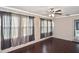 Living room featuring hardwood-style flooring, ceiling fan, and large windows with curtains at 5905 Olive Ave, Sarasota, FL 34231