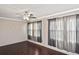 Living room featuring hardwood-style flooring, ceiling fan, and large windows with curtains at 5905 Olive Ave, Sarasota, FL 34231