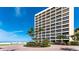 Luxury high-rise condo building overlooking a beautiful beach with tropical landscaping at the entry at 5966 Midnight Pass Rd # G-51 & G-58, Sarasota, FL 34242