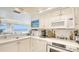 Bright white kitchen featuring sleek countertops, white cabinets, and water views at 5966 Midnight Pass Rd # G-51 & G-58, Sarasota, FL 34242