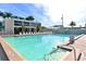 Large pool area with plenty of lounge chairs and palm trees, creating a relaxing resort-style atmosphere for residents at 5966 Midnight Pass Rd # G-51 & G-58, Sarasota, FL 34242