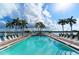 Beautiful waterfront pool surrounded by palm trees and lounge chairs, perfect for relaxation and enjoying the scenic views at 5966 Midnight Pass Rd # G-51 & G-58, Sarasota, FL 34242