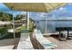 Scenic waterfront view featuring lounge chairs, lush landscaping, and grilling area for a relaxing outdoor experience at 5966 Midnight Pass Rd # G-51 & G-58, Sarasota, FL 34242