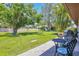 Expansive backyard with lush green grass, mature trees, and a patio area perfect for outdoor dining at 6010 36Th Avenue W Cir # E, Bradenton, FL 34209
