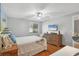 Bedroom featuring tropical decor, ceiling fan, wood floors, and a large wicker dresser at 6010 36Th Avenue W Cir # E, Bradenton, FL 34209