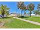 Inviting community entrance with lush landscaping, palm trees and well-maintained sidewalk at 6010 36Th Avenue W Cir # E, Bradenton, FL 34209