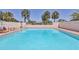 Relaxing community pool with palm trees, lounge chairs, and well-maintained walls at 6010 36Th Avenue W Cir # E, Bradenton, FL 34209