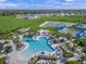An aerial view of the community pool surrounded by lounge chairs, palm trees, and recreation areas at 6244 Talon Preserve Dr, Nokomis, FL 34275