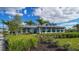 Clubhouse with lush landscaping, palm trees, and large windows on a beautiful day at 6244 Talon Preserve Dr, Nokomis, FL 34275