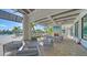 Beautiful clubhouse patio with comfortable seating, a fireplace, a TV, and a view of the pool and tropical landscaping at 6244 Talon Preserve Dr, Nokomis, FL 34275