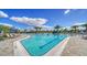 Large community pool with ample lounge seating, palm trees, and clear blue water on a sunny day at 6244 Talon Preserve Dr, Nokomis, FL 34275