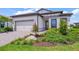 Charming single-story home featuring a well-manicured lawn, an attached two-car garage, and beautiful landscaping at 6244 Talon Preserve Dr, Nokomis, FL 34275