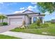 Well-manicured front yard with lush landscaping, a paved driveway, and a two-car garage at 6244 Talon Preserve Dr, Nokomis, FL 34275