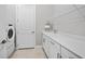 Functional laundry room with modern appliances, ample counter space, and storage cabinets at 6244 Talon Preserve Dr, Nokomis, FL 34275