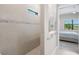 Modern shower with tile surround is adjacent to the bedroom with outdoor views at 6244 Talon Preserve Dr, Nokomis, FL 34275