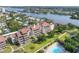 Aerial view of condo building with a pool, greenspace, and river views at 6285 Midnight Pass Rd # 403, Sarasota, FL 34242