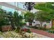 Beautifully landscaped entrance with lush greenery, benches, and a chandelier, creating a serene and welcoming atmosphere at 6285 Midnight Pass Rd # 403, Sarasota, FL 34242