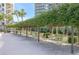 Outdoor seating area featuring multiple tables and chairs arranged beneath trees at 6285 Midnight Pass Rd # 403, Sarasota, FL 34242