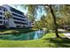 Beautiful view of condo building, pond with fountains, and sidewalk in community at 6285 Midnight Pass Rd # 403, Sarasota, FL 34242