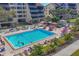Aerial view of a sparkling pool surrounded by lounge chairs, umbrellas, and tropical landscaping at 6285 Midnight Pass Rd # 403, Sarasota, FL 34242