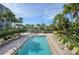 Inviting swimming pool with lounge chairs and palm trees, with ocean view in background at 6285 Midnight Pass Rd # 403, Sarasota, FL 34242