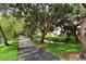 Scenic walkway alongside a tranquil canal with lush greenery and mature trees at 6285 Midnight Pass Rd # 403, Sarasota, FL 34242