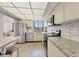 Bright kitchen features stainless steel appliances, granite countertops, tile backsplash, and light wood flooring at 6285 Midnight Pass Rd # 403, Sarasota, FL 34242