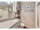 Well-lit bathroom featuring a granite countertop, built-in cabinets, and framed decorative art at 6615 12Th Ave W W Ave, Bradenton, FL 34209