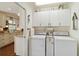 Functional laundry room with a set of washer and dryer, cabinets, and an adjacent kitchen at 6615 12Th Ave W W Ave, Bradenton, FL 34209