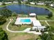 Aerial view of a sparkling pool and clubhouse overlooking a scenic lake at 6615 12Th Ave W W Ave, Bradenton, FL 34209