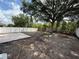 Spacious backyard with a wooden swing set, concrete patio area, and a white vinyl fence at 6711 Cambridge Park Dr, Apollo Beach, FL 33572