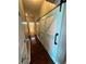Hallway featuring a sliding barn door, hardwood floors, and bathroom access at 6711 Cambridge Park Dr, Apollo Beach, FL 33572