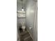 Powder room with modern toilet, shelving, gray walls, and wood-look flooring at 6711 Cambridge Park Dr, Apollo Beach, FL 33572