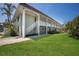 Two story condo building with large lawn and white balconies and stairways at 7100 Gulf Dr # 114, Holmes Beach, FL 34217