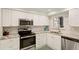 Updated kitchen features white cabinets, stainless steel appliances, and granite countertops at 7100 Gulf Dr # 114, Holmes Beach, FL 34217