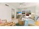 Bright living room features a cozy sofa, rattan chairs, stylish coffee table, and a TV for entertainment at 7100 Gulf Dr # 114, Holmes Beach, FL 34217