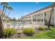 Exterior view of a community pool surrounded by lush landscaping and a multi-story condo building at 7100 Gulf Dr # 114, Holmes Beach, FL 34217